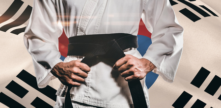 Fighter tightening karate belt against korea republic flag wavingの写真素材