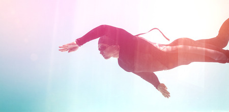 Young man with arm raised while swimming underwaterの写真素材