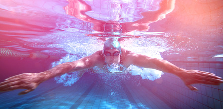 Fit swimmer training by himself in the swimming pool at the leisure centreの写真素材