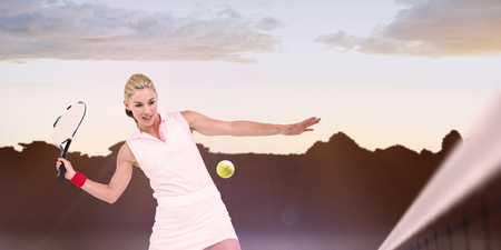 Athlete playing tennis with a racket  against composite image of landscapeの写真素材