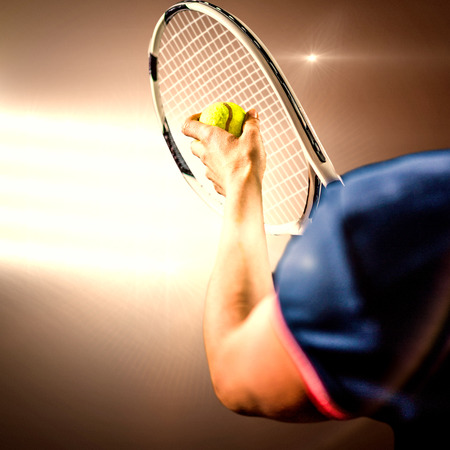 Tennis player holding a racquet ready to serve  against spotlightsの写真素材