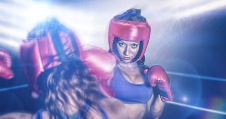 Rear view of fighter flexing muscles against boxing ring illuminatedの写真素材