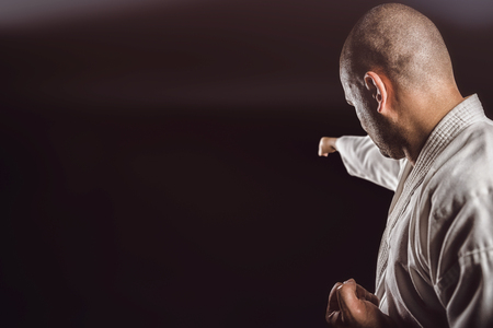 Fighter performing karate stance against black backgroundの写真素材