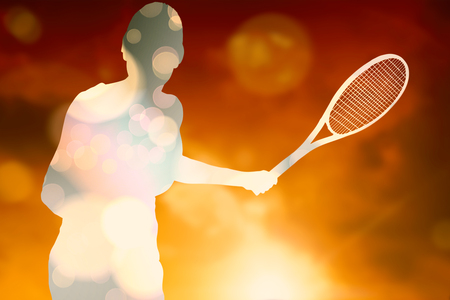 Female athlete playing tennis against landscape with sunsetの写真素材