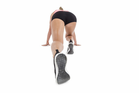 Female athlete on the start line on white background