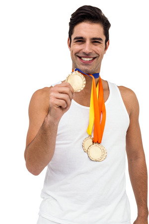 Portrait of athlete posing with gold medals around his neck on white backgroundの写真素材