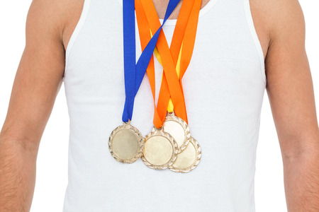 Mid section of athlete posing with gold medals around his neck on white background