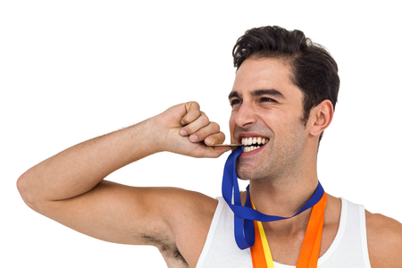 Male athlete posing with gold medals around his neck on white backgroundの写真素材