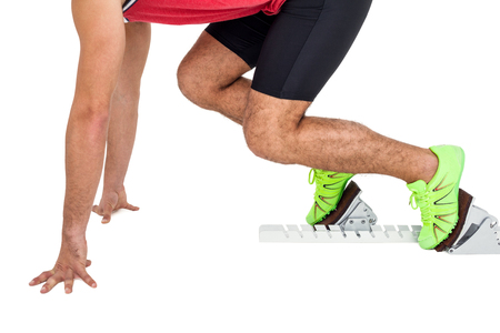 Male athlete in ready to run position on white backgroundの写真素材