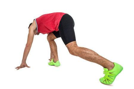 Male athlete in ready to run position on white background