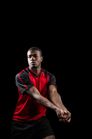 Sportsman posing while playing volleyball on black backgroundの写真素材