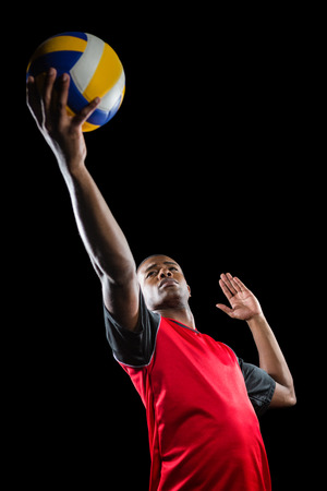 Sportsman playing a volleyball on black backgroundの写真素材