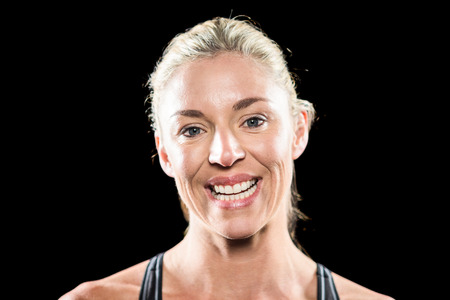 Close-up of athlete smiling on black background