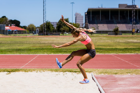 Female athlete performing a long jump during a competition