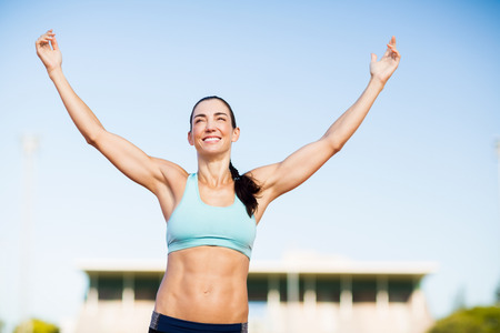 Happy female athlete posing after a victory on racing trackの写真素材