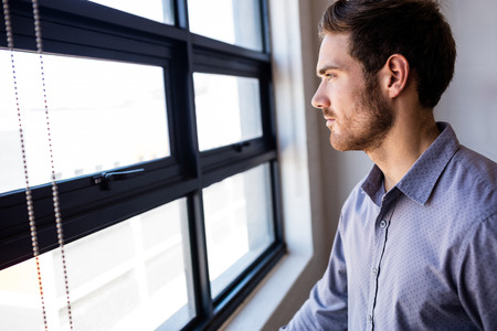 Businessman looking out of the window of the office