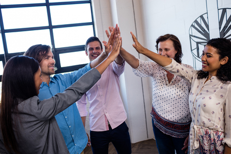 Group of coworkers putting hands together in the office