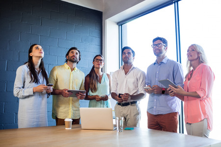 Group of coworkers using laptops and smartphones in the office