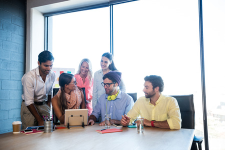 Group of coworkers using a tablet computer in the office