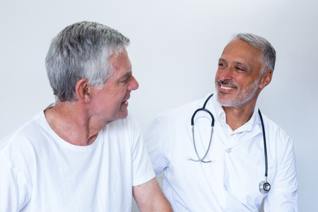 Male doctor and senior man interacting with each other in hospitalの写真素材