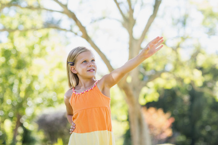 Cute young girl playing with a paper plane in parkの写真素材