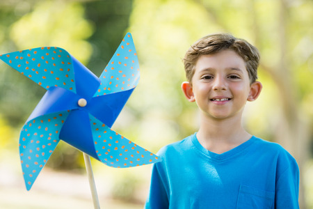 Portrait of boy holding a pinwheel in parkの写真素材