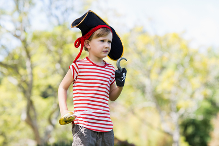 Boy pretending to be a pirate in parkの写真素材