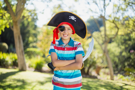 Portrait of smiling boy pretending to be a pirate in the park on a sunny dayの写真素材