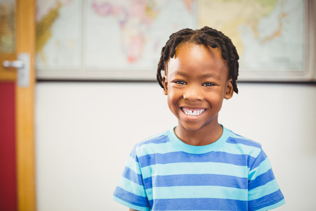 Portrait of smiling schoolboy in classroom at school