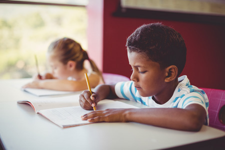 School kids doing homework in classroom at schoolの写真素材