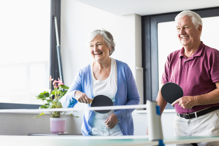 Seniors playing ping-pong in a retirement homeの写真素材