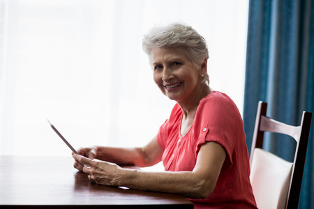 Senior woman using a tablet in a retirement homeの写真素材