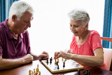 Senior couple playing chess in a retirement homeの写真素材
