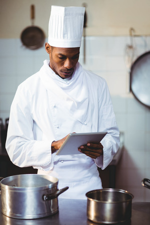 Chef using digital tablet in kitchenの写真素材