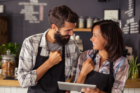 Two waiters using a tablet computer in the barの写真素材