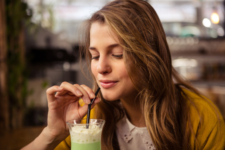 Casual woman drinking a cocktail in the restaurantの写真素材