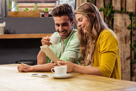 Lovely couple using a tablet computer in the restaurantの写真素材