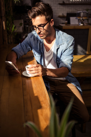 Man holding a cup of coffee in the cafeの写真素材