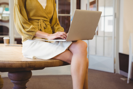 Businesswoman posing on her desk at workの写真素材