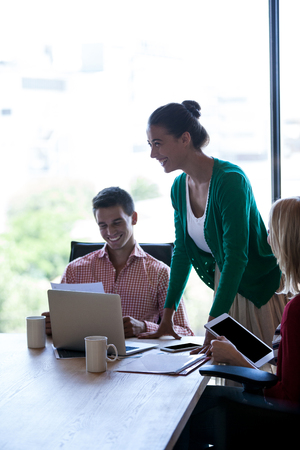 Coworkers smiling during a meeting in the officeの写真素材