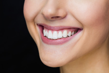 Focus on womans smile in a black backgroundの写真素材