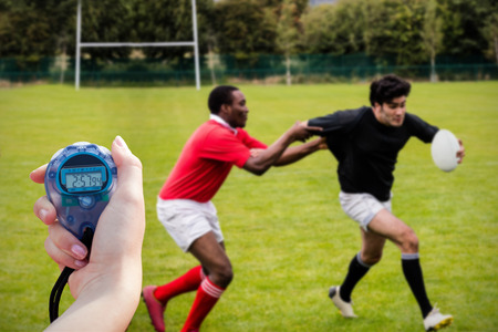 Close up of a hand holding a timer during a rugby matchの写真素材