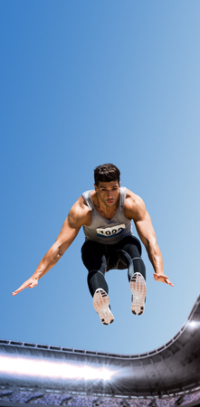 Front view of sportsman is jumping against composite image of a stadium