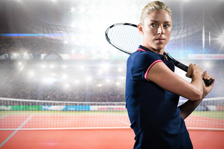 Concentrated sportswoman playing tennis in a courtの写真素材
