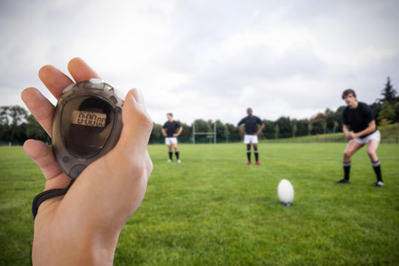 Close up of a hand holding a timer during a rugby matchの写真素材