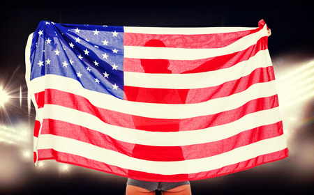 Athlete posing with american flag after victory against american football arena