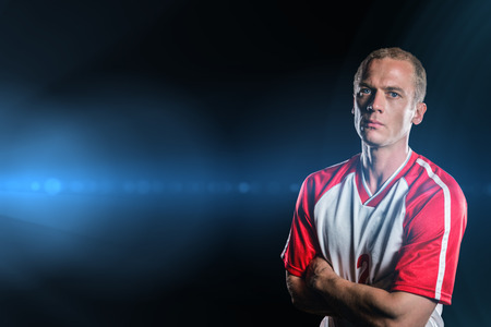 Portrait of volleyball player with arms crossed against spotlightsの写真素材