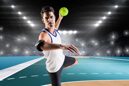 Portrait of athlete man throwing a ball  against handball field indoorの写真素材