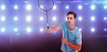 Badminton player playing badminton against composite image of blue spotlightの写真素材