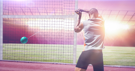 Rear view of sportsman practising hammer throw against race trackの写真素材